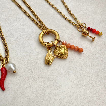 Gold necklaces with various charms on a light background