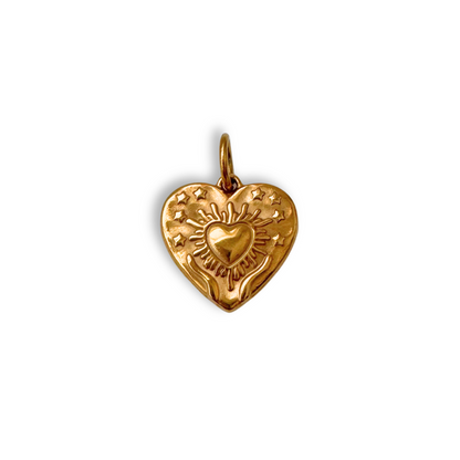 Gold heart-shaped pendant with engraved design on a white background