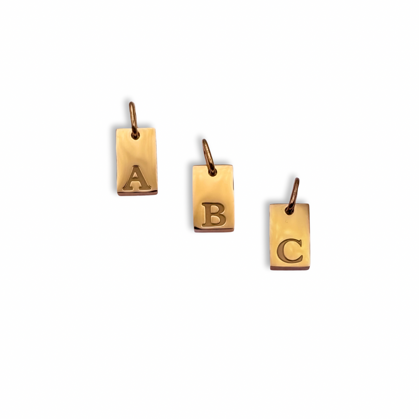 Three gold pendants with letters A, B, and C on a white background