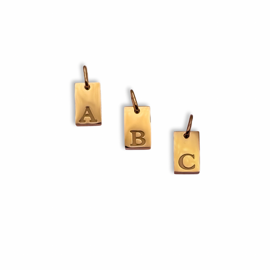 Three gold pendants with letters A, B, and C on a white background