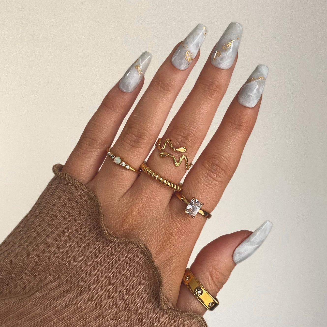 gold rings including beaded ring, snake ring, zircon ring, opal ring. On hand with marble nails